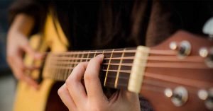 Man playing the guitar, receiving a blessing through music